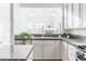 Well-lit kitchen features white cabinets, granite countertops, and stainless steel appliances at 1699 N Downing St # 409, Denver, CO 80218