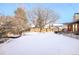 Large snow-covered backyard offers ample space and privacy, with a wooden fence surrounding the property at 9770 Quitman Way, Westminster, CO 80031