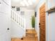 Bright foyer with hardwood floors, white staircase, and stylish front door at 9770 Quitman Way, Westminster, CO 80031