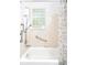 Bathroom includes a white tub and shower combo with tiled walls and a glass block window for natural light at 633 W 114Th Way, Northglenn, CO 80234