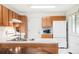 Functional kitchen featuring ample cabinet space, white appliances, and a peninsula sink at 633 W 114Th Way, Northglenn, CO 80234