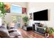 Bright living room with wood floors, a fireplace, large windows, and access to a deck at 633 W 114Th Way, Northglenn, CO 80234