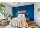 Bright bedroom with a blue accent wall, hardwood floors, and natural light from the large window at 6001 Castlegate Dr # A33, Castle Rock, CO 80108