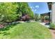 The spacious backyard features lush green grass and stone landscaping, providing privacy and natural beauty at 2347 S Loveland St, Lakewood, CO 80228