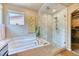 Elegant bathroom featuring a soaking tub, separate glass shower, and natural light at 2347 S Loveland St, Lakewood, CO 80228