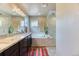 Modern bathroom featuring dual vanities, a soaking tub, and a separate glass-enclosed shower at 2347 S Loveland St, Lakewood, CO 80228
