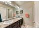 Stylish bathroom featuring double sinks, dark wood cabinets, and unique tile accents at 2347 S Loveland St, Lakewood, CO 80228