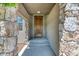 Inviting entryway with stone pillars, a wooden front door, and recessed lighting, providing a warm welcome at 2347 S Loveland St, Lakewood, CO 80228