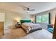 Inviting main bedroom with neutral tones, ceiling fan, and a large window overlooking the backyard at 2347 S Loveland St, Lakewood, CO 80228