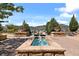 Beautiful water feature with landscaped patio, chairs, and views of the mountains in the distance at 2347 S Loveland St, Lakewood, CO 80228