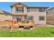 Backyard of a two-story home featuring a wood deck, lawn, and an exterior painted in neutral colors at 10695 Wynspire Rd, Highlands Ranch, CO 80130