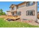 Two-story home featuring a backyard with wood deck, lawn, garden area, and exterior in neutral earth tone colors at 10695 Wynspire Rd, Highlands Ranch, CO 80130