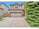 Two-story home featuring a tan exterior with a large driveway leading to a two-car garage at 10695 Wynspire Rd, Highlands Ranch, CO 80130