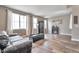 Living room with hardwood floors, dark furniture, three large bright windows, and neutral colored walls at 10695 Wynspire Rd, Highlands Ranch, CO 80130