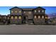 Stylish townhome featuring a stone facade, dark gray siding, and well-maintained landscaping at 9836 Mount Kataka Pt, Littleton, CO 80125