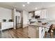 Well-lit kitchen with stainless steel appliances, stone countertops, and hardwood floors at 9836 Mount Kataka Pt, Littleton, CO 80125