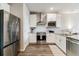 Contemporary kitchen with white cabinets, stainless steel appliances, and hardwood floors at 9836 Mount Kataka Pt, Littleton, CO 80125