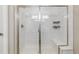 Modern bathroom with a frameless glass shower, white tile and bench seating at 9836 Mount Kataka Pt, Littleton, CO 80125