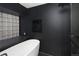 Modern black bathroom with free-standing tub, glass block window, and rainfall shower head at 3731 N Race St, Denver, CO 80205