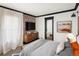 This primary bedroom features a brick wall, a dresser, and a door leading to the ensuite bathroom at 3731 N Race St, Denver, CO 80205