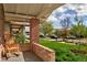 Charming front porch featuring brick columns and a rocking chair, overlooking the front yard at 3731 N Race St, Denver, CO 80205