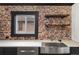 Close-up on kitchen sink with stainless steel finish and floating shelving on brick wall at 3731 N Race St, Denver, CO 80205