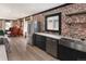 Open kitchen with modern stainless steel appliances and brick accent wall at 3731 N Race St, Denver, CO 80205
