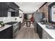 Modern kitchen leads to a dining area, featuring stainless appliances and black cabinetry at 3731 N Race St, Denver, CO 80205