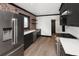 Modern kitchen with stainless steel appliances, dark cabinets, and brick accent wall at 3731 N Race St, Denver, CO 80205