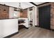 Entryway with landing, shelves, brick wall, and stylish black door at 3731 N Race St, Denver, CO 80205