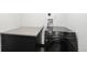 A modern laundry room featuring a front load washer, countertop, and storage cabinet at 3731 N Race St, Denver, CO 80205