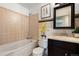 Bright bathroom featuring a bathtub, tiled walls, modern vanity, and decorative accents at 17934 E Purdue Pl, Aurora, CO 80013