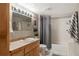 Bathroom featuring a single sink vanity, a large mirror, and a shower/tub combo at 17934 E Purdue Pl, Aurora, CO 80013