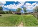 Beautiful backyard showcasing an ample pasture area, outbuildings, and mature shade trees at 10220 W Montgomery Ave, Littleton, CO 80127