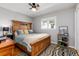 Bright bedroom with hardwood floors, a wooden bed frame, and a large window view at 10220 W Montgomery Ave, Littleton, CO 80127