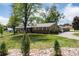 Charming single-story home with a brick facade, lush lawn, mature trees and a driveway leading to a two car garage at 10220 W Montgomery Ave, Littleton, CO 80127