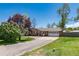 Charming brick home with an attached garage, long driveway and mature trees at 10220 W Montgomery Ave, Littleton, CO 80127