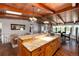 Open kitchen with wood-beamed ceilings, a large island, hardwood floors and contemporary lighting at 10220 W Montgomery Ave, Littleton, CO 80127
