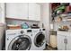 Functional laundry room with a modern washer and dryer, storage cabinets, shelving and sink at 10220 W Montgomery Ave, Littleton, CO 80127