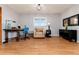 Bright living room featuring hardwood floors, a reading chair, and a workspace with a window at 10220 W Montgomery Ave, Littleton, CO 80127