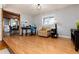 Light-filled living space with wood floors, cozy armchair, and workspace by the window at 10220 W Montgomery Ave, Littleton, CO 80127