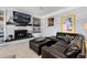 Cozy living room with a white brick fireplace, leather couch, and built-in shelves at 10220 W Montgomery Ave, Littleton, CO 80127