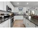 Kitchen with white cabinets, stainless steel appliances, and view to dining area at 697 N Bersshine Ct, Watkins, CO 80137