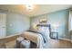 Cozy bedroom featuring soft blue walls, plush bedding, and two gray ottomans at 2539 N York St, Denver, CO 80205