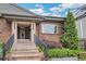 Charming brick home featuring a covered entryway, dual front doors, and professionally landscaped yard at 2539 N York St, Denver, CO 80205