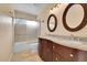 Bathroom featuring a double vanity with granite countertop and shower over tub at 9411 La Quinta Way, Lone Tree, CO 80124
