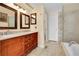 Well-lit bathroom featuring a double vanity, tiled floor, and glass shower at 9411 La Quinta Way, Lone Tree, CO 80124