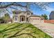Inviting two-story home with brick and siding, a three-car garage, and a lush green lawn at 9411 La Quinta Way, Lone Tree, CO 80124
