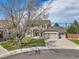Inviting two-story home with a three-car garage, a landscaped front yard, and mature trees at 9411 La Quinta Way, Lone Tree, CO 80124