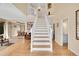 Bright foyer with hardwood floors, staircase, and views into the living and dining areas at 9411 La Quinta Way, Lone Tree, CO 80124